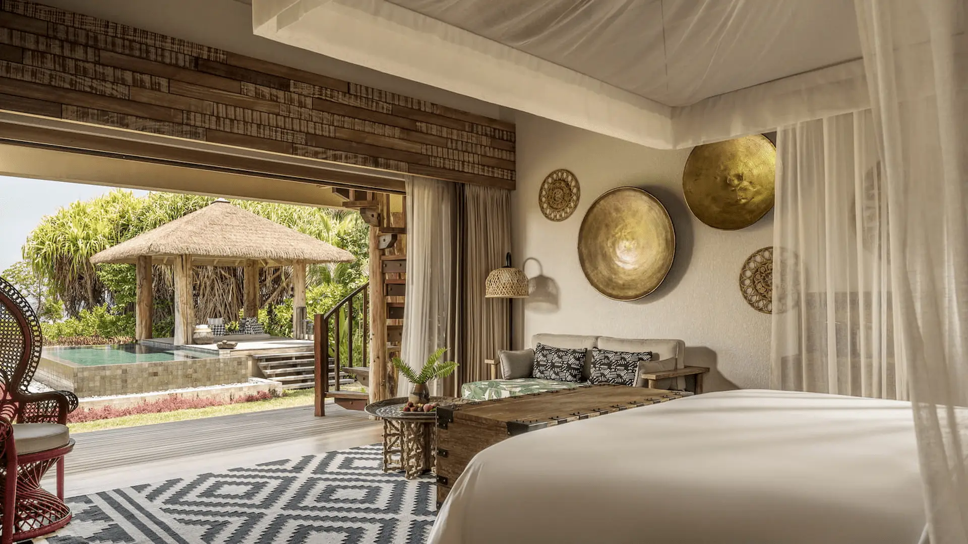 bedroom view from a pool villa at four seasons resort desroches seychelles overlooking the pool and sunset sky