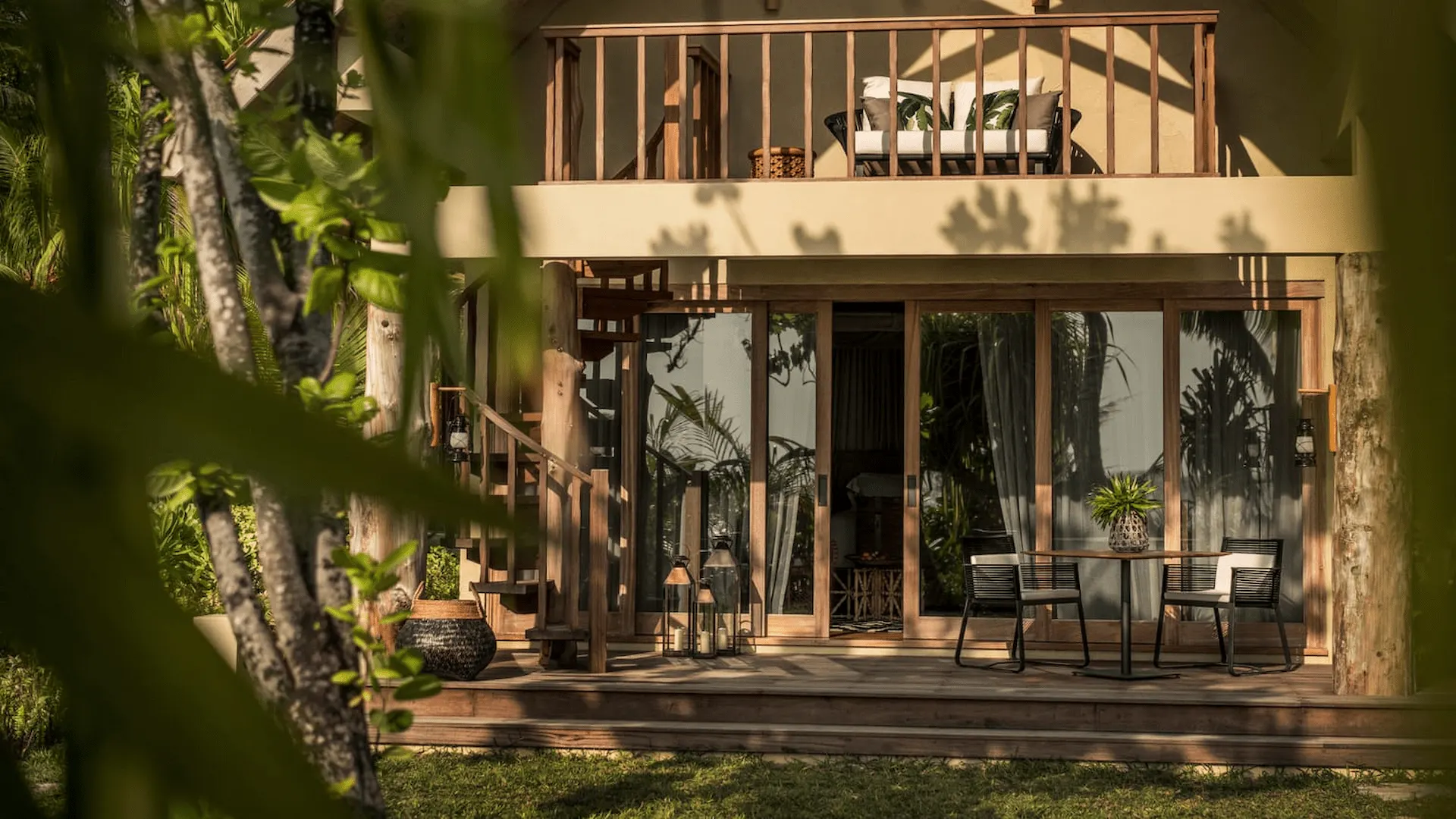 terrace doors of a pool villa at four seasons resort desroches seychelles opening to a sunset view over the ocean