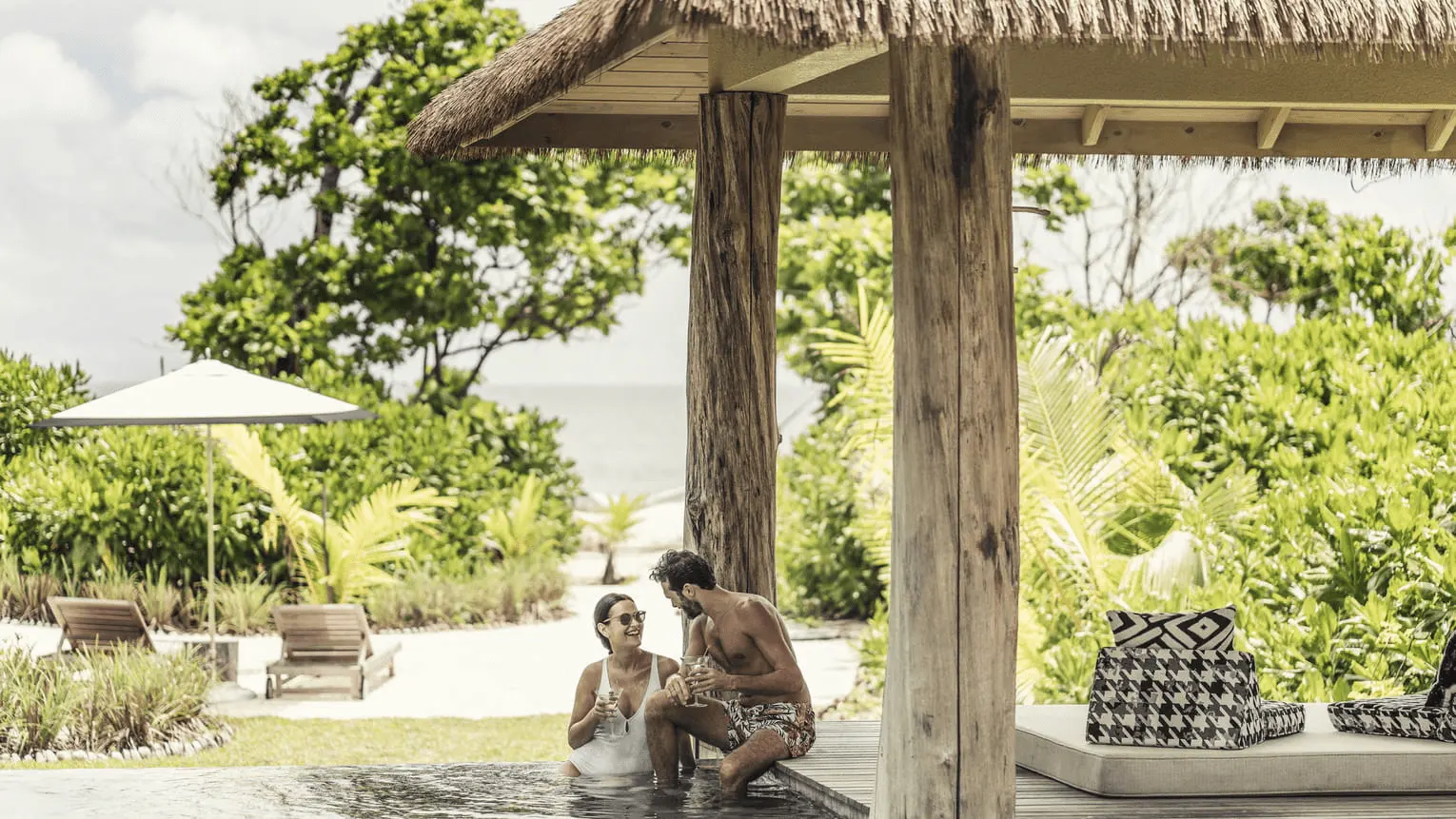 terrace of a pool villa at four seasons resort desroches seychelles with sunset view over the ocean and horizon