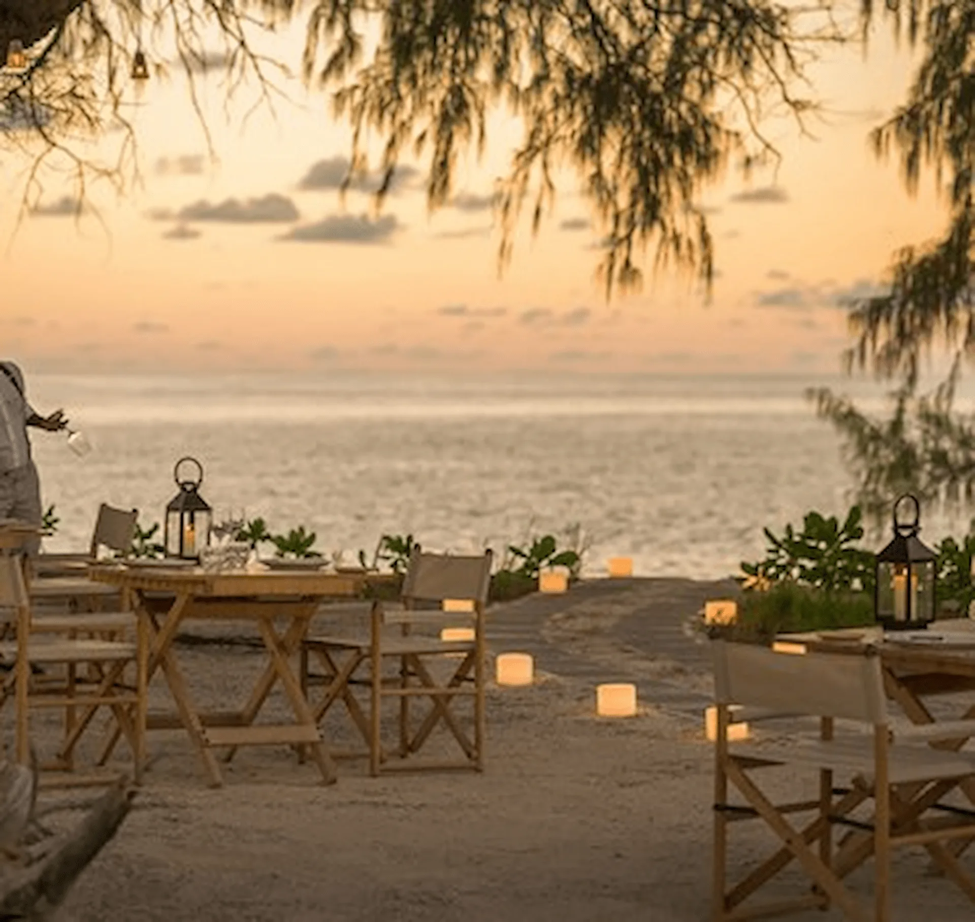 beach seating area at the lighthouse restaurant at four seasons resort desroches seychelles with tables and ocean views
