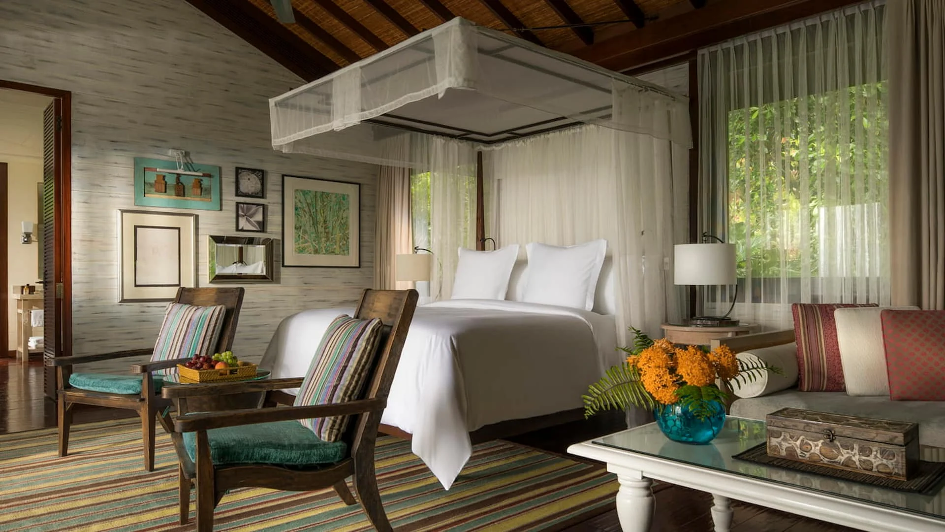 bedroom in a garden view villa at Four Seasons Resort Seychelles with a large bed and views of surrounding tropical greenery