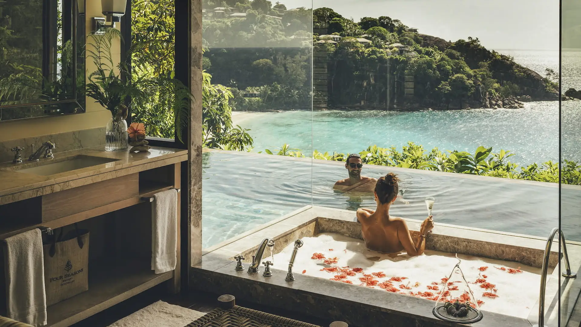 bath and pool area in a hillside ocean view villa at Four Seasons Resort Seychelles with open air design and views over tropical surroundings