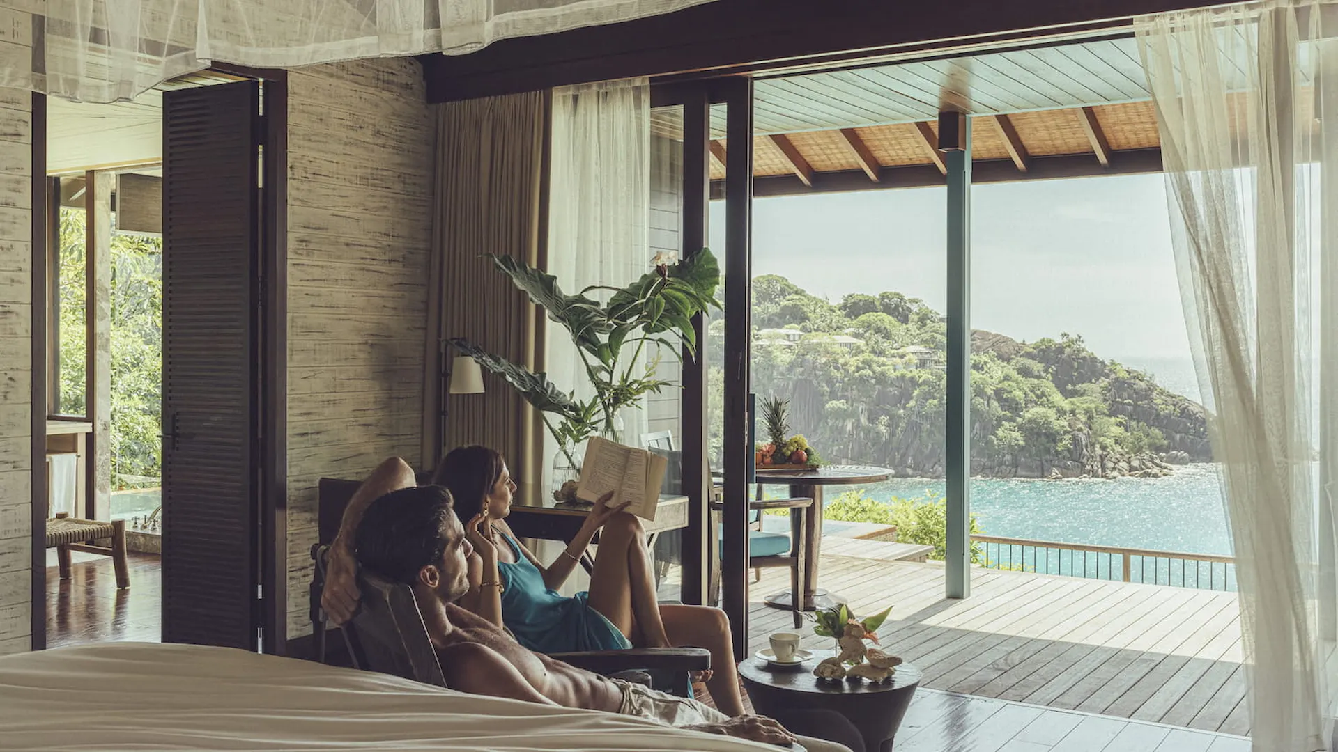 view from a hillside ocean view villa at Four Seasons Resort Seychelles overlooking lush tropical forest and the turquoise ocean beyond