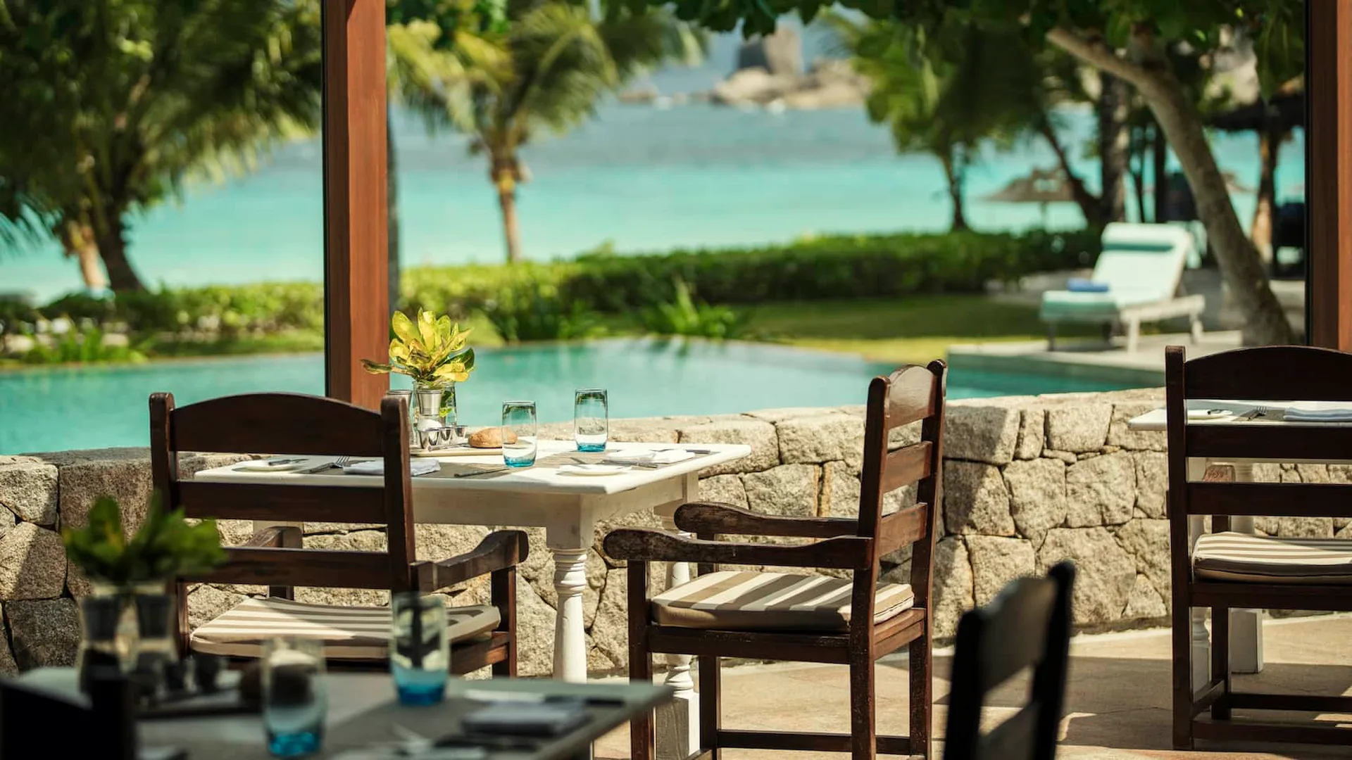 kannel restaurant at Four Seasons Resort Seychelles with open air dining area overlooking the ocean and tropical surroundings