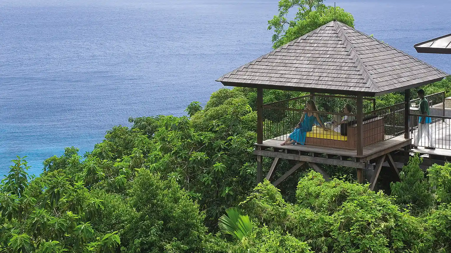 aerial view of ocean view villas at Four Seasons Resort Seychelles set on a hillside overlooking the sea and tropical forest