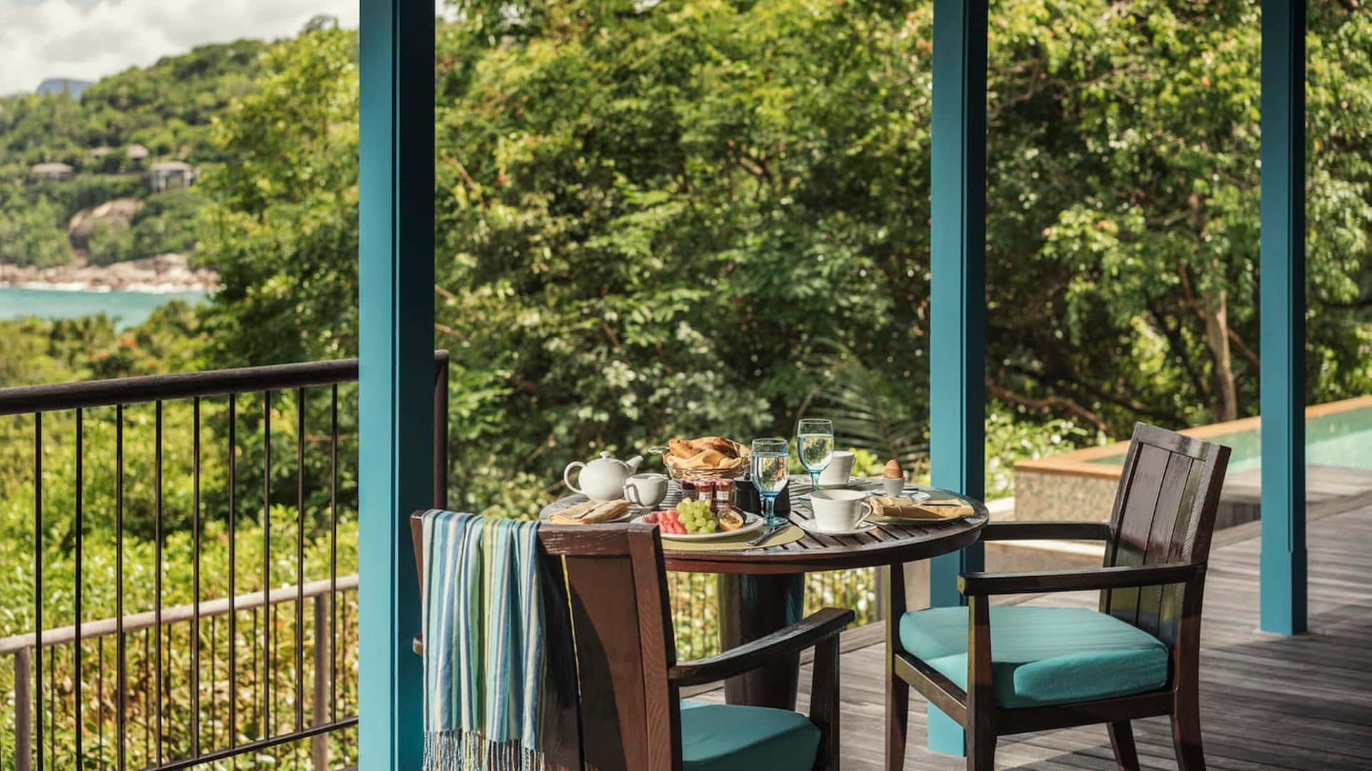 balcony of an ocean view villa at Four Seasons Resort Seychelles overlooking tropical greenery and the ocean horizon