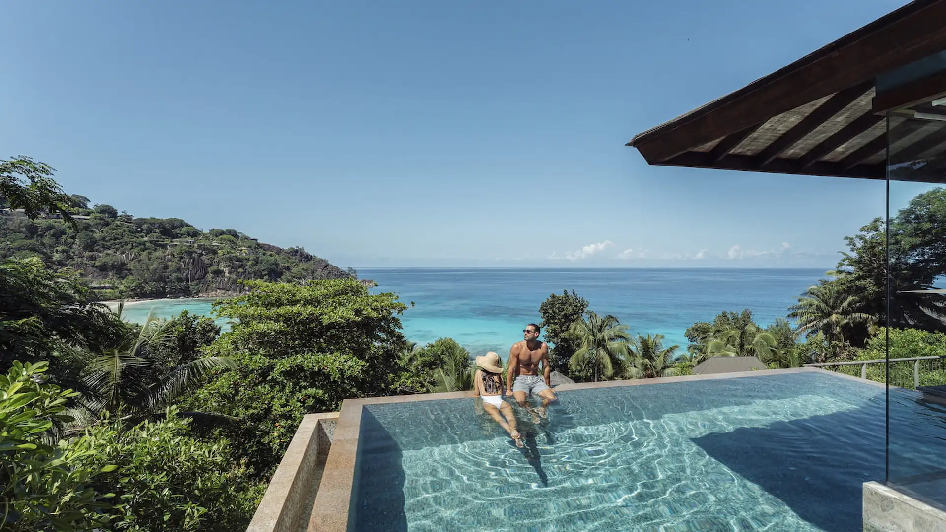 couple relaxing by the private pool of a serenity villa at Four Seasons Resort Seychelles surrounded by tropical greenery and ocean views