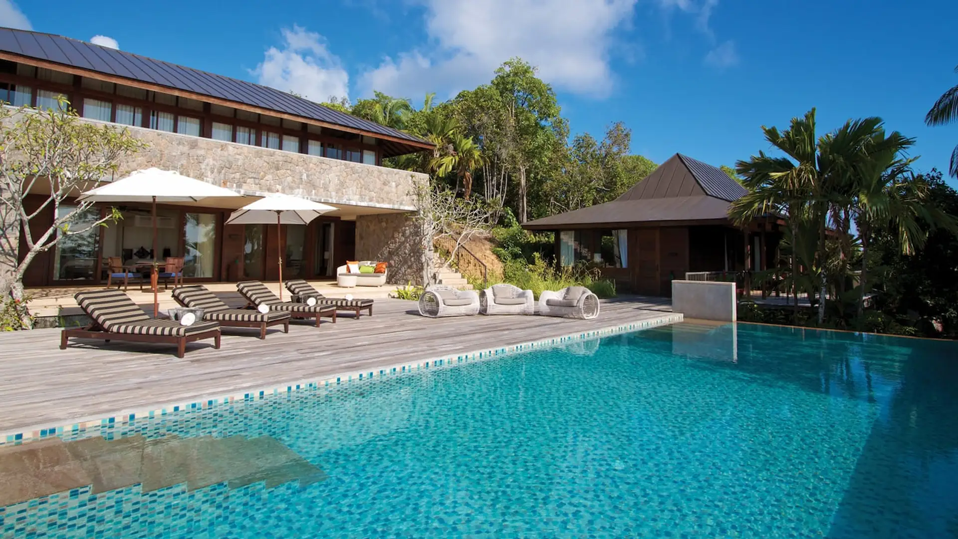 private pool of a three bedroom residence at Four Seasons Resort Seychelles surrounded by tropical greenery with ocean views