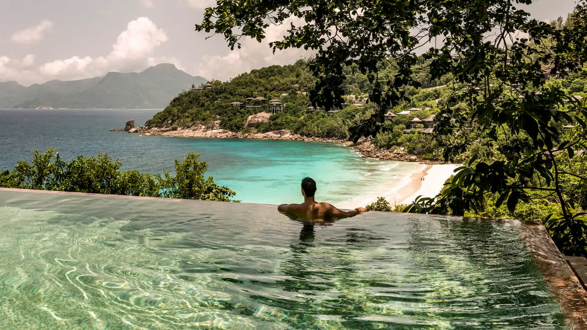 aerial view of a two bedroom ocean view villa at Four Seasons Resort Seychelles with surrounding tropical forest and clear turquoise sea