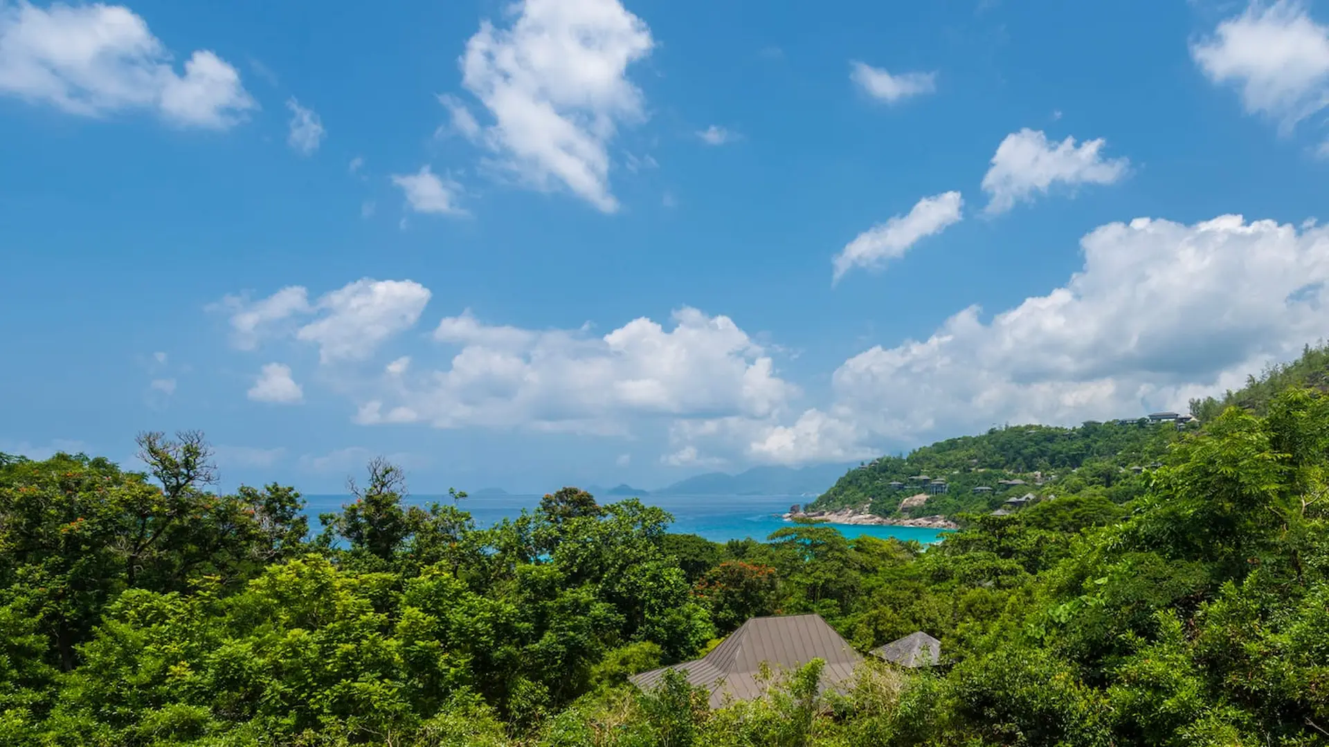 aerial view of a two bedroom ocean view villa at Four Seasons Resort Seychelles set on a hillside with tropical forest and ocean coastline