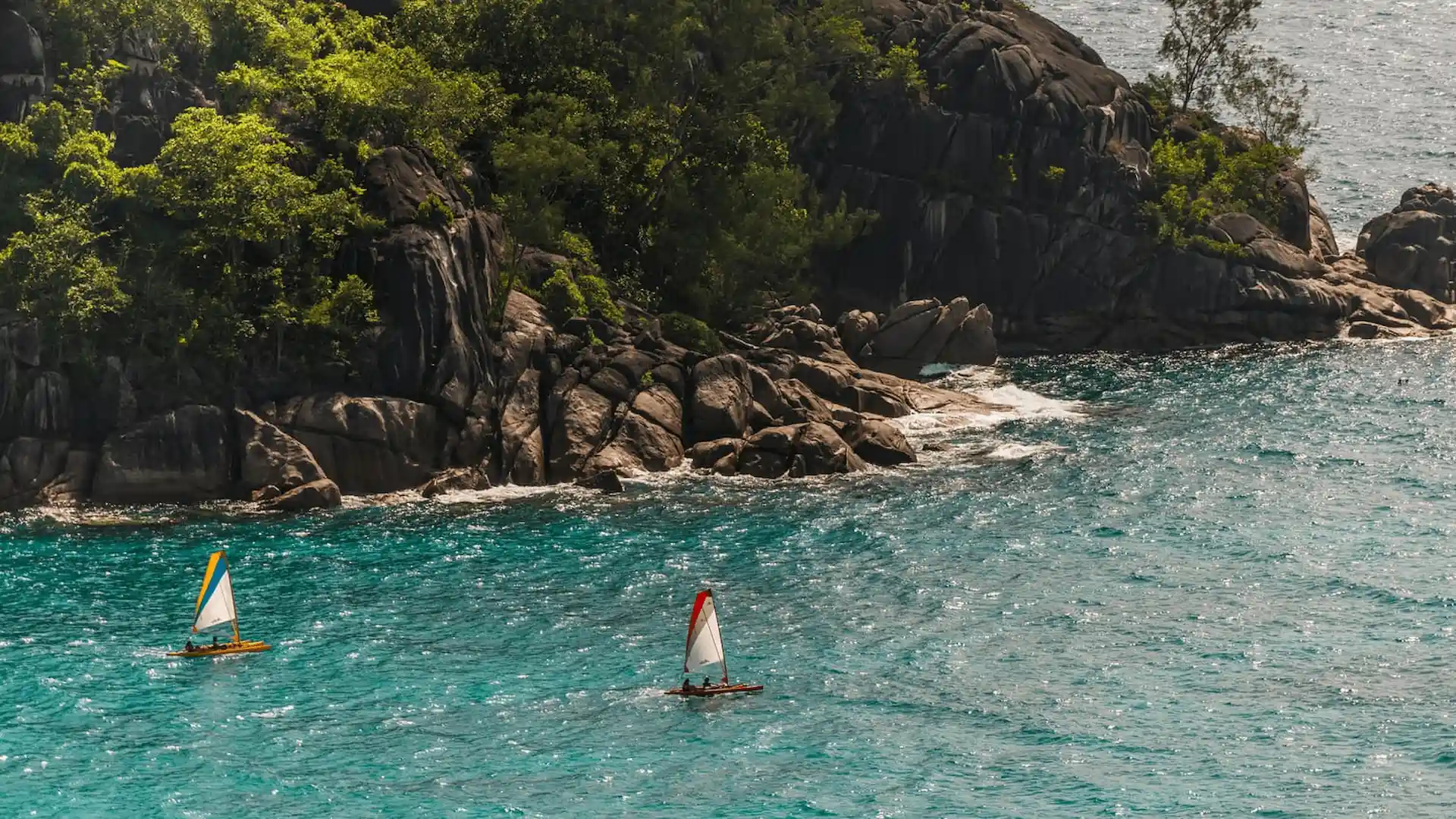 water sports at Four Seasons Resort Seychelles with guests kayaking and enjoying activities in clear turquoise ocean waters