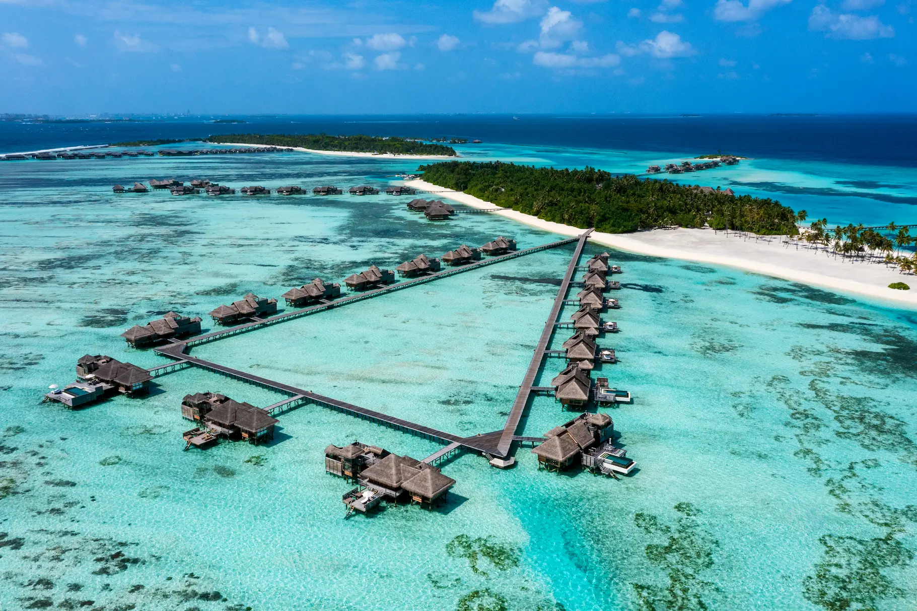 a sweeping all jetty over water villas aerial view at gili lankanfushi maldives overlooking the calm turquoise lagoon