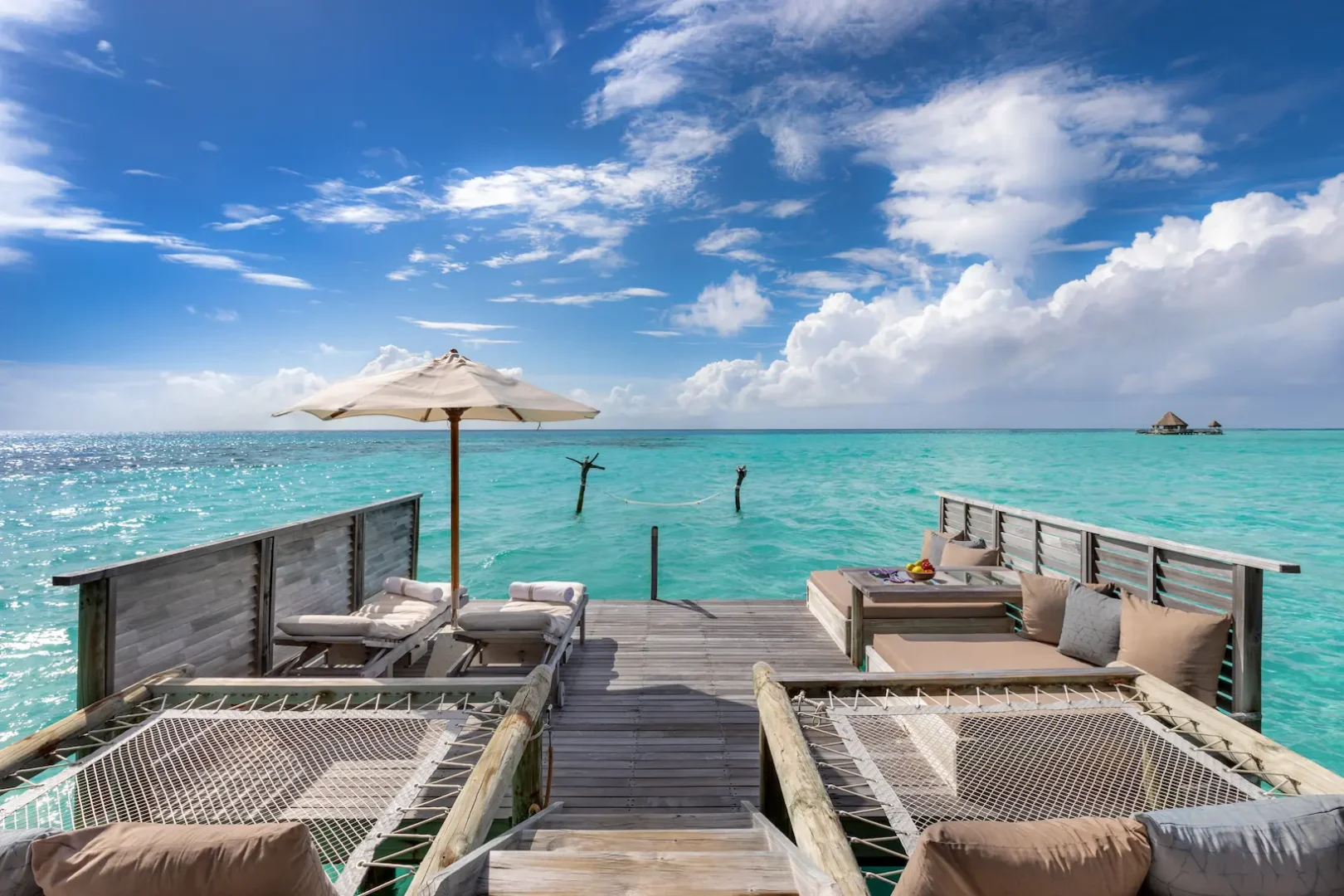 a spacious crusoe residence deck at gili lankanfushi maldives overlooking calm turquoise lagoon waters