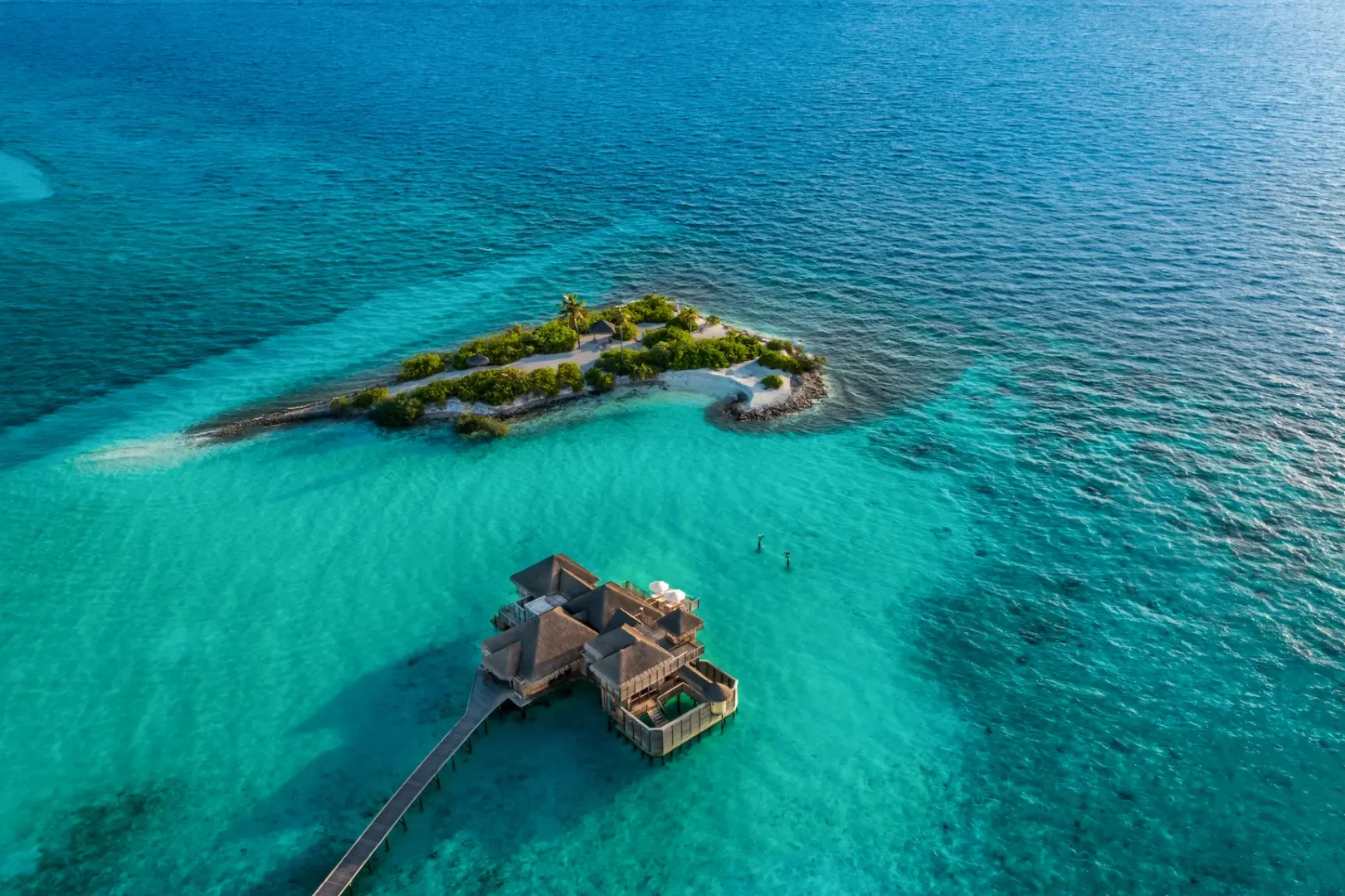an elevated family villa aerial private island view at gili lankanfushi maldives overlooking calm turquoise lagoon waters