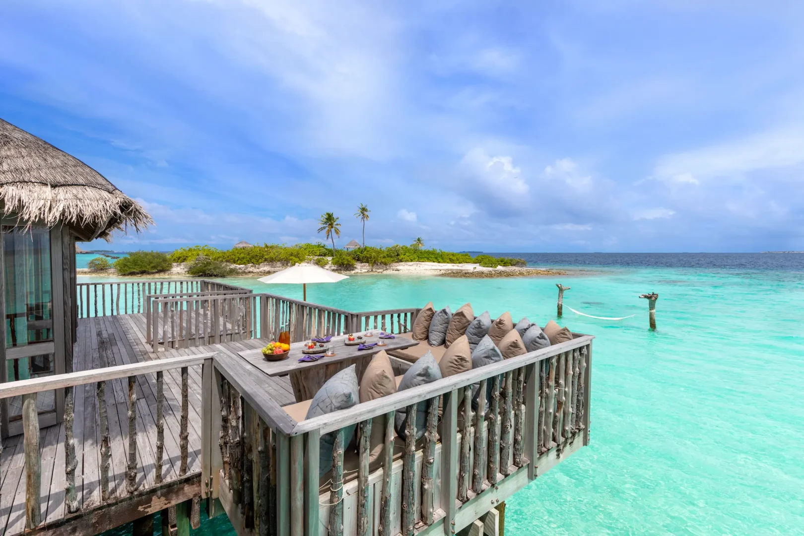a spacious family villa deck at gili lankanfushi maldives overlooking calm turquoise lagoon waters