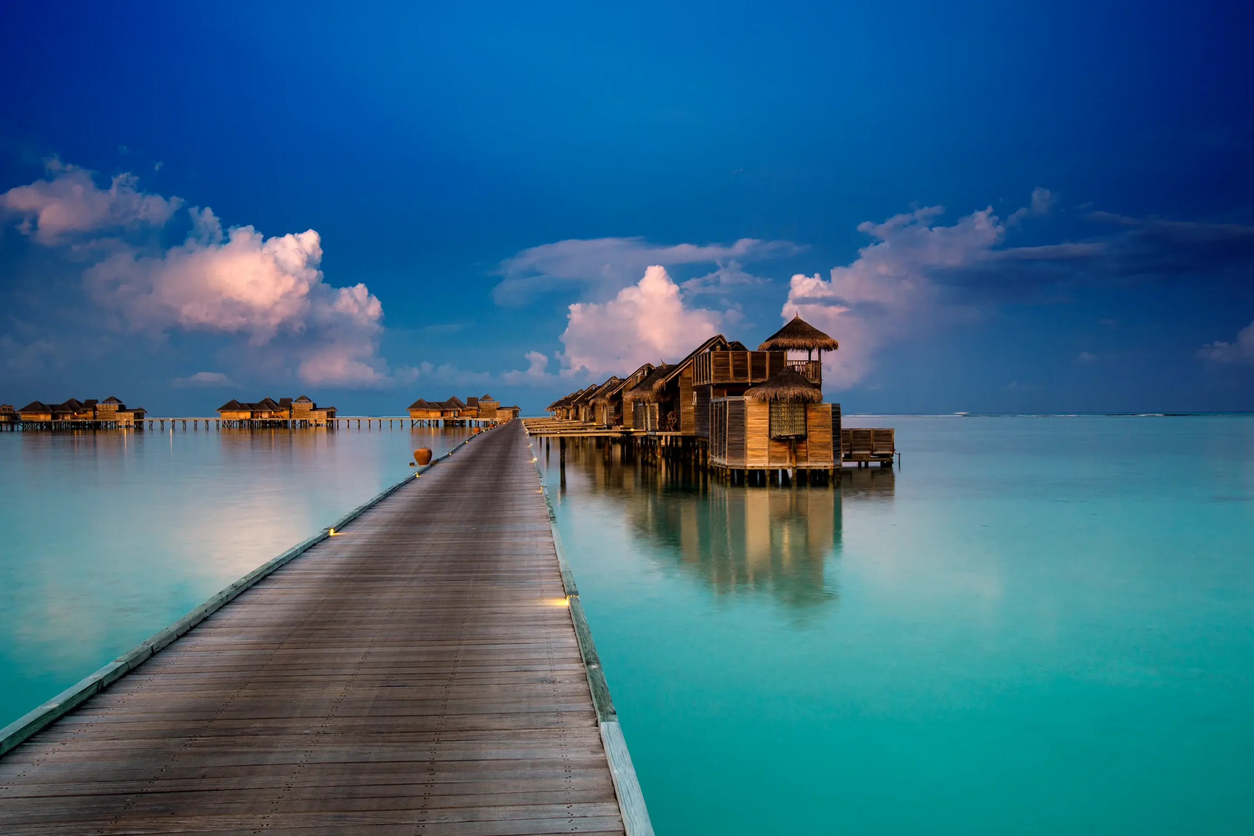 a serene jetty one villa suites exterior scene at gili lankanfushi maldives overlooking calm turquoise lagoon waters