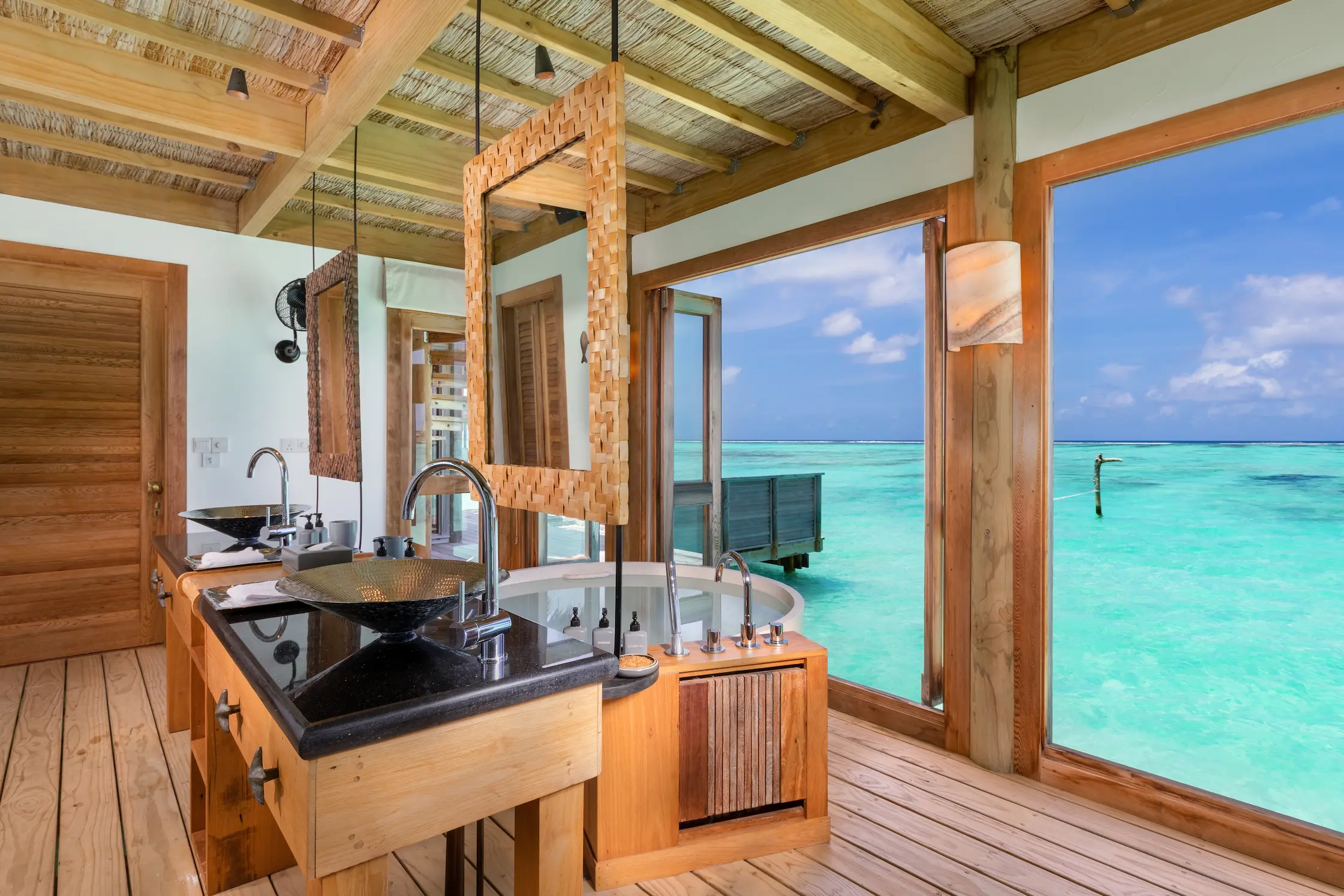 a serene private reserve bathroom at gili lankanfushi maldives featuring natural textures and calming overwater ambience