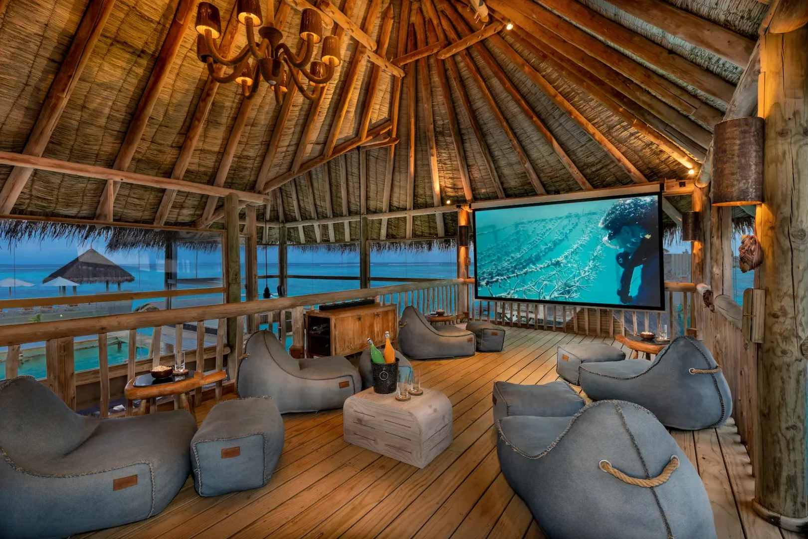 a cosy private reserve cinema at gili lankanfushi maldives featuring warm natural tones and a serene overwater setting