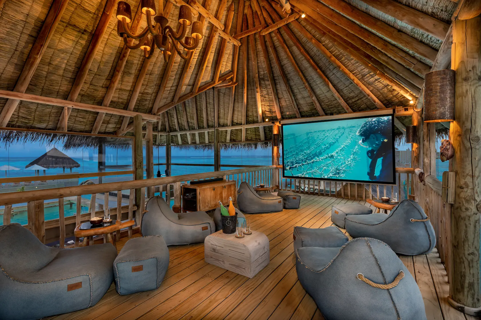 a cosy private reserve cinema at gili lankanfushi maldives featuring warm natural tones and a serene overwater setting