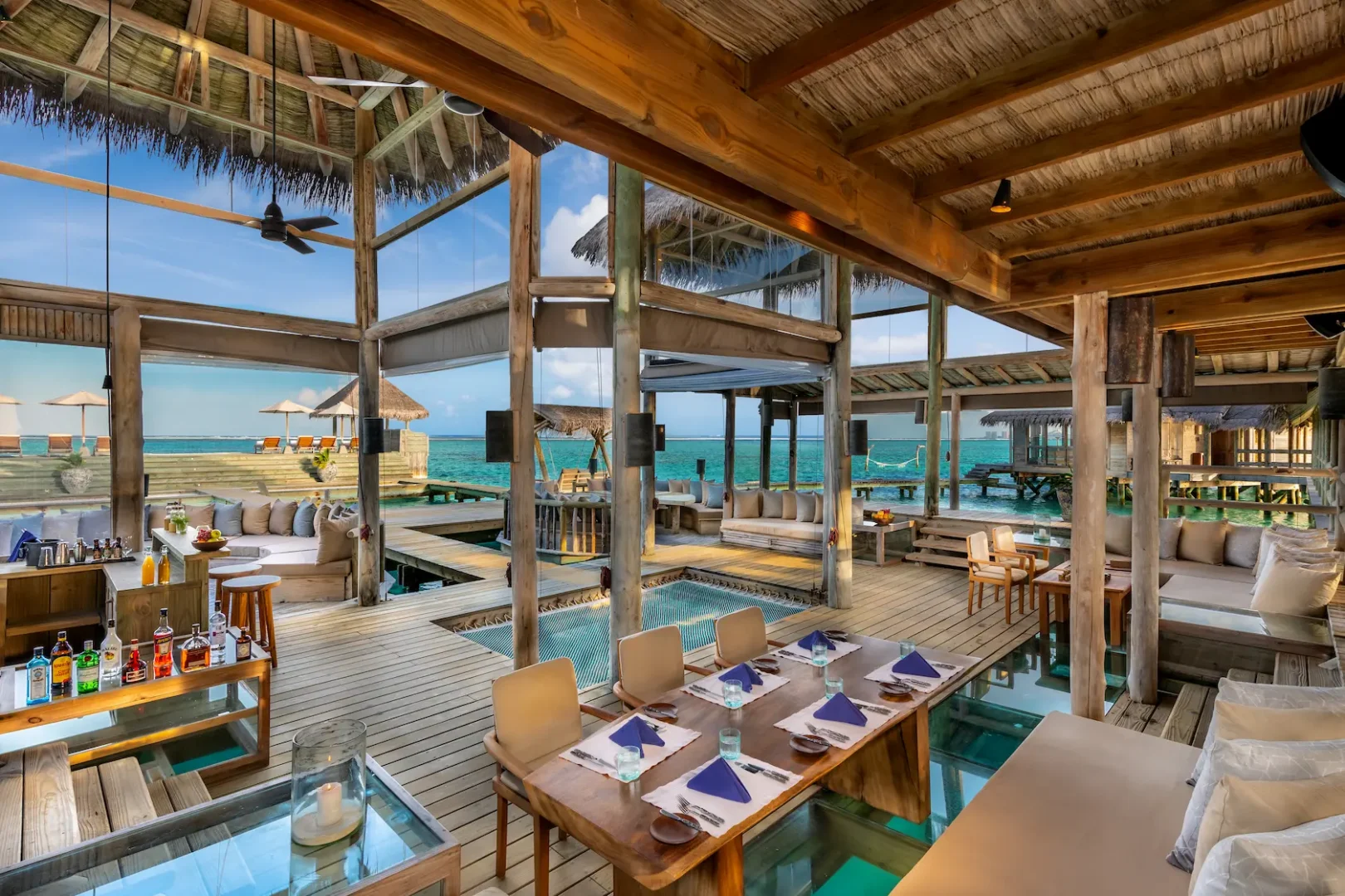 a refined private reserve downstairs indoor dining space at gili lankanfushi maldives featuring natural textures and serene lagoon ambience