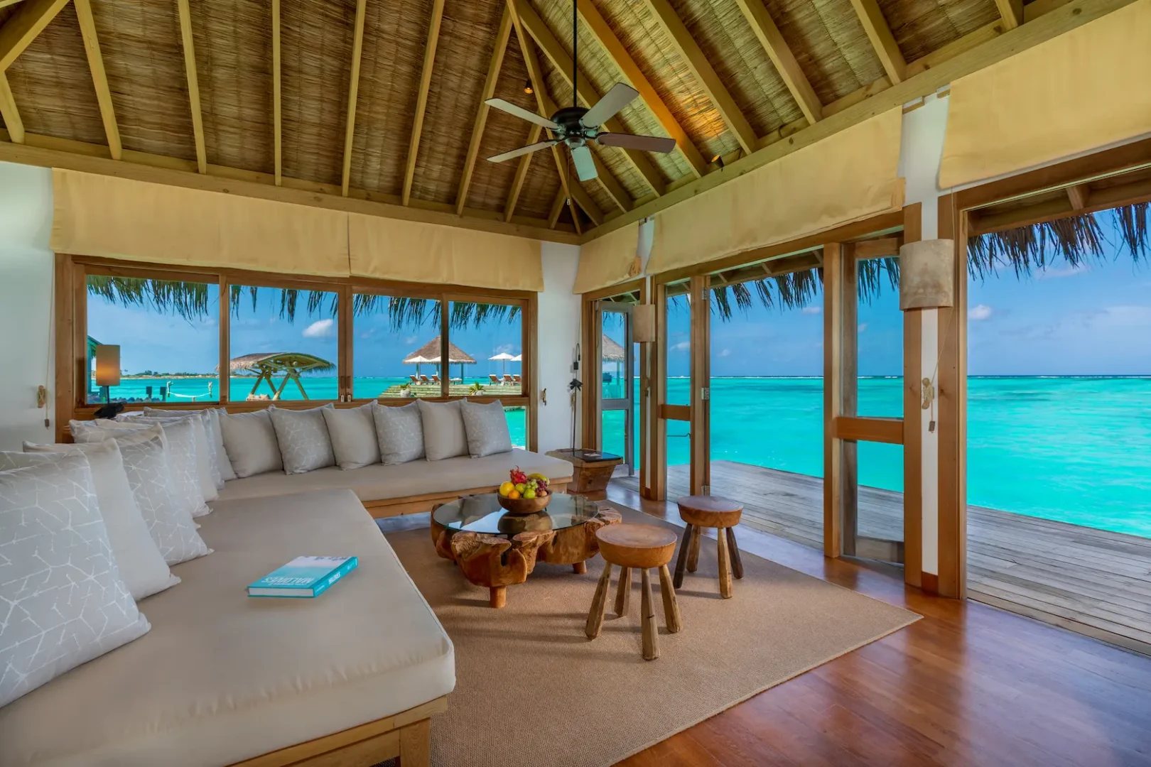a spacious private reserve master living area at gili lankanfushi maldives featuring natural materials and open lagoon views