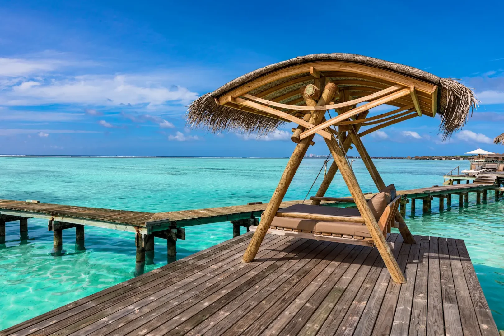 a relaxing private reserve outdoor swing at gili lankanfushi maldives set above calm turquoise lagoon waters