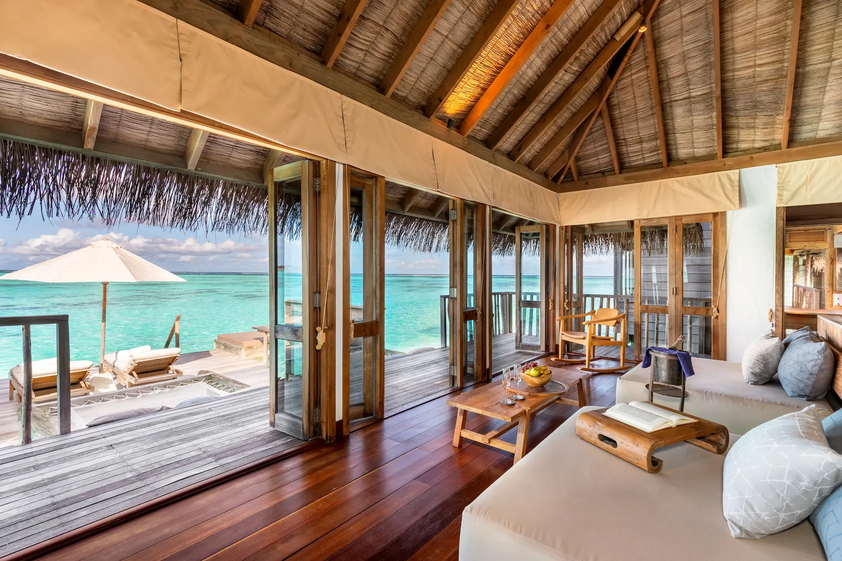 a spacious residence living area at gili lankanfushi maldives featuring natural materials and open lagoon views