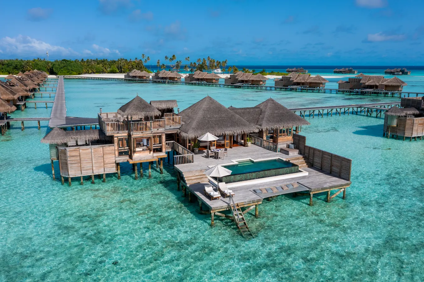 an elevated exterior view of the residence with pool at gili lankanfushi maldives overlooking clear turquoise lagoon waters