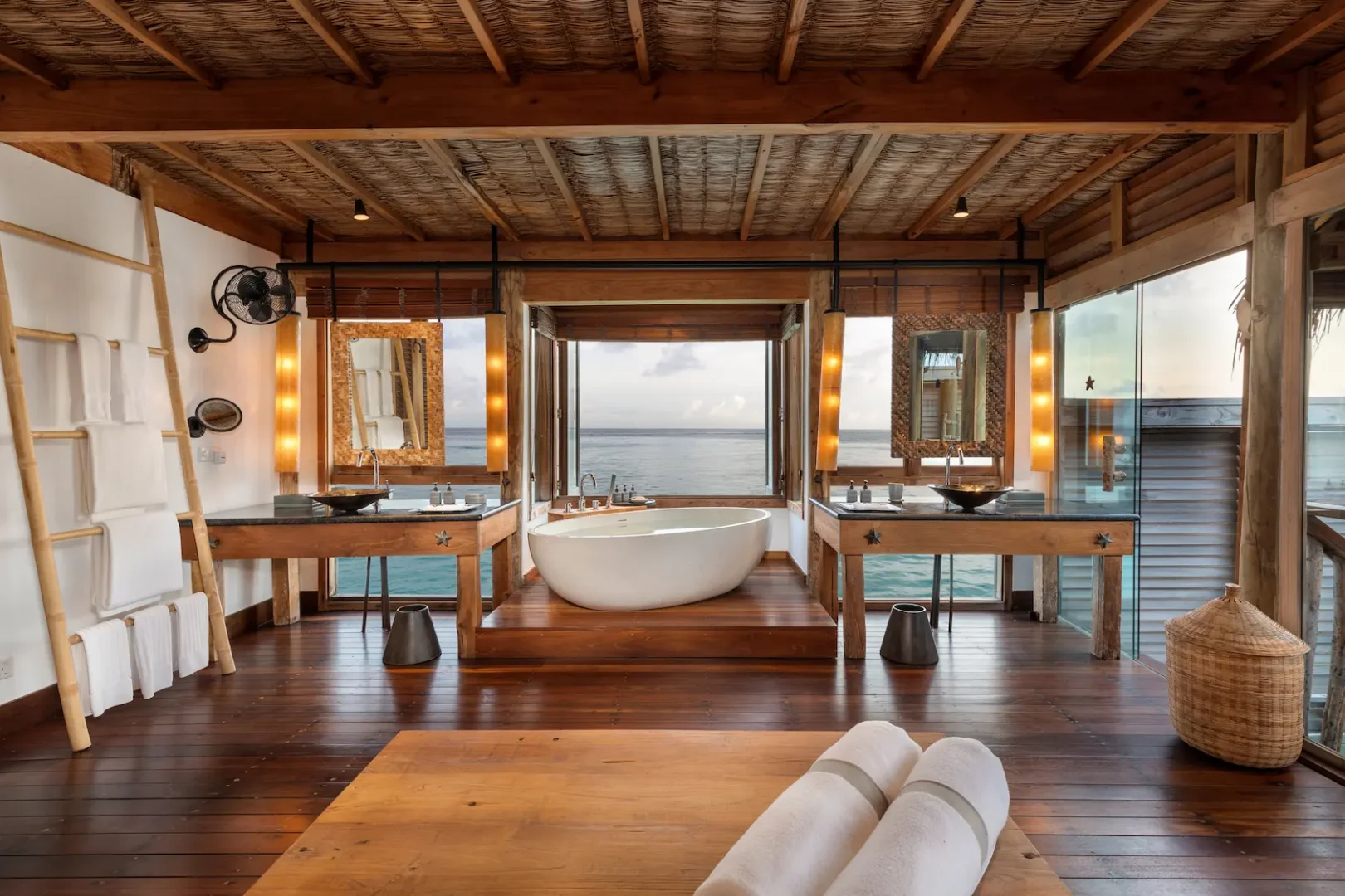 a serene overwater villa suite bathroom at gili lankanfushi maldives featuring natural wood and open airy design
