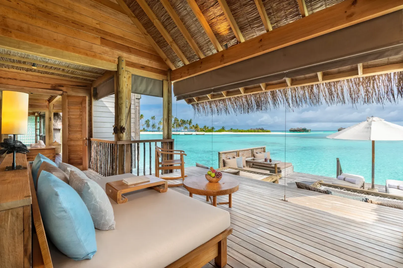 a spacious overwater villa suite living room at gili lankanfushi maldives with calm natural finishes and open ocean ambience