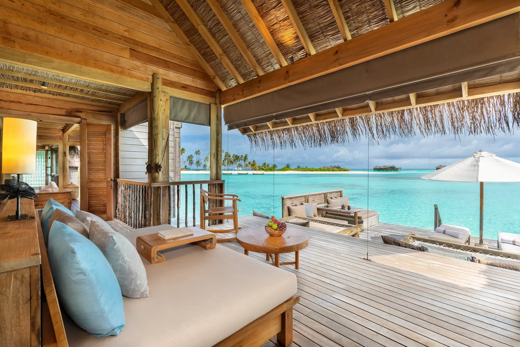 a spacious overwater villa suite living room at gili lankanfushi maldives with calm natural finishes and open ocean ambience