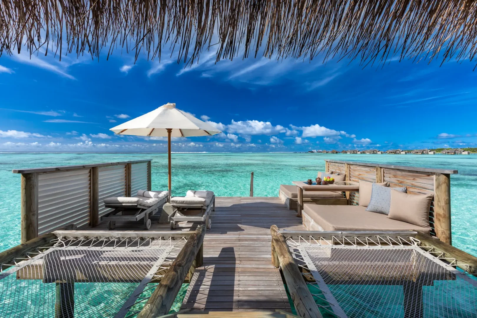 a sunlit overwater villa suite sun deck at gili lankanfushi maldives overlooking calm turquoise waters