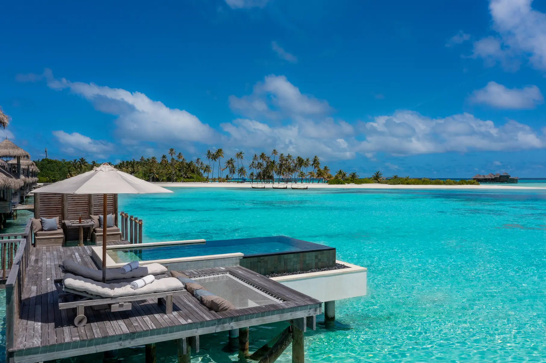 a serene overwater villa suite with pool deck sunbed at gili lankanfushi maldives set beside calm turquoise water