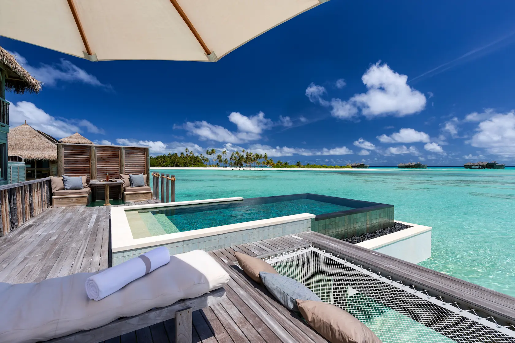 a relaxing overwater villa suite with pool deck at gili lankanfushi maldives overlooking calm clear ocean water