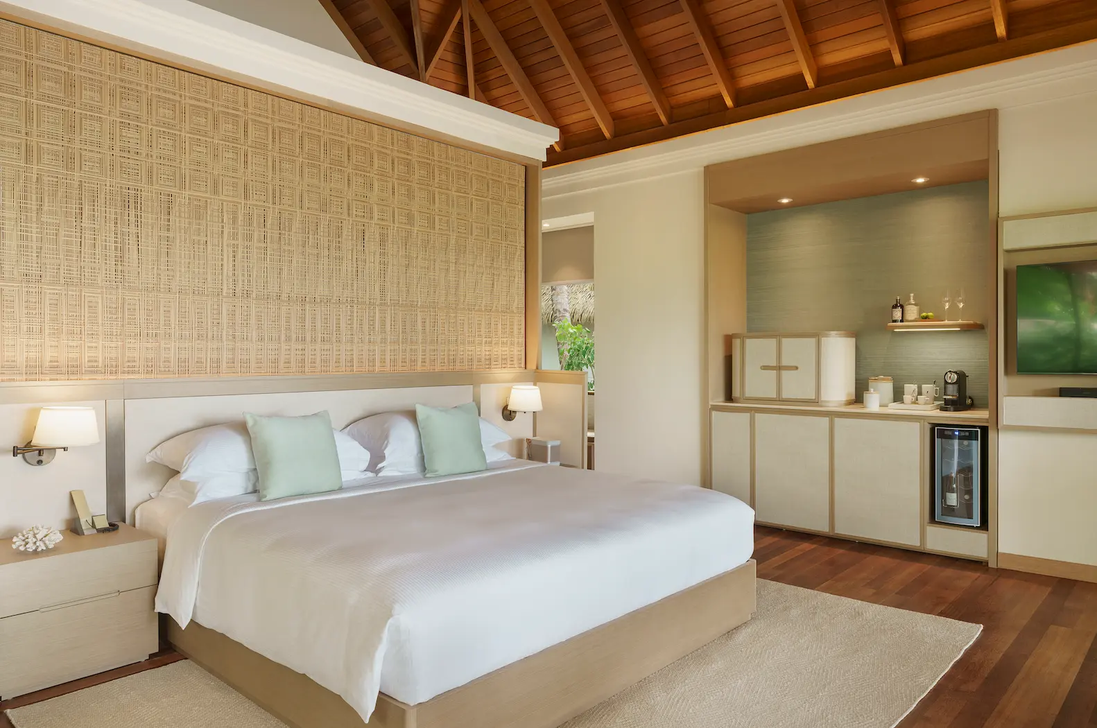 heritance aarah maldives deluxe beach bungalow bedroom featuring an elegant beachfront sleeping space with soft island light and refined tropical ambience