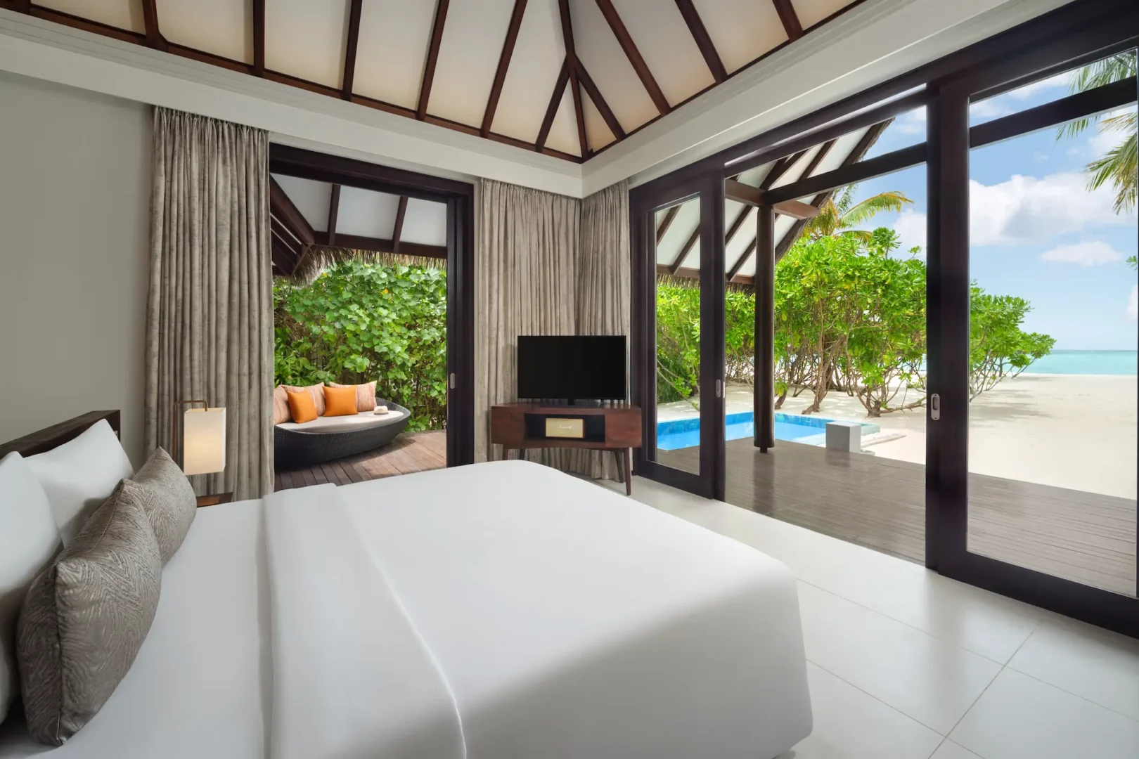 heritance aarah maldives family beach pool villa king bed room featuring an elegant beachfront interior with warm natural textures and serene tropical ambience