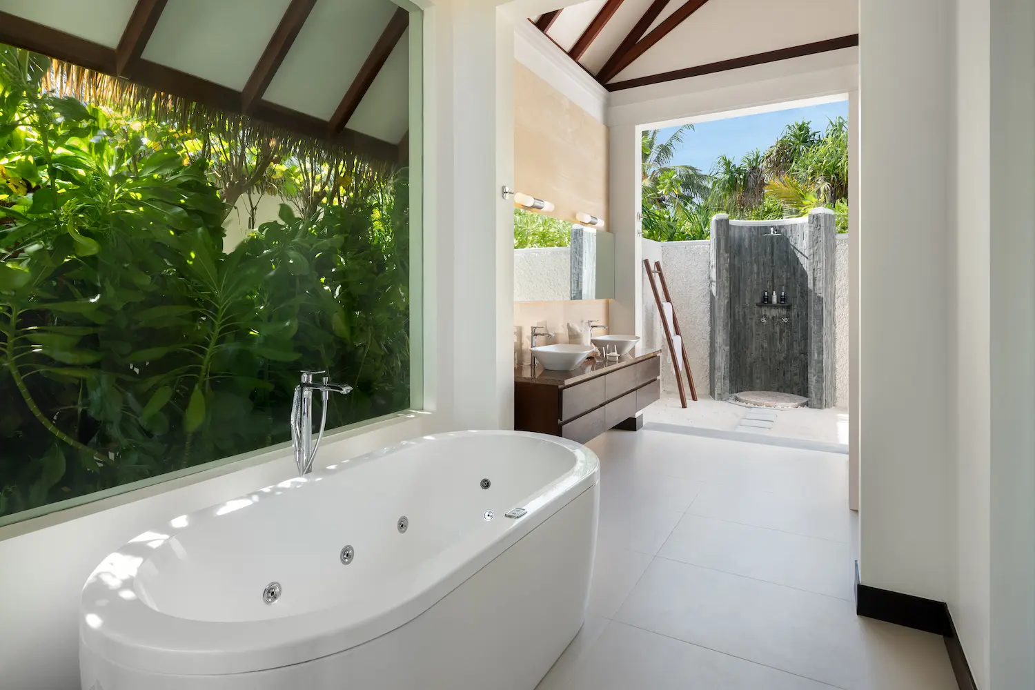 heritance aarah maldives family beach villa bathroom and outdoor shower featuring a serene open air design with elegant natural finishes