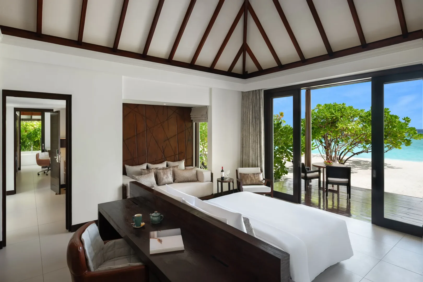 heritance aarah maldives family beach villa king bed room featuring an elegant beachfront interior with warm natural textures