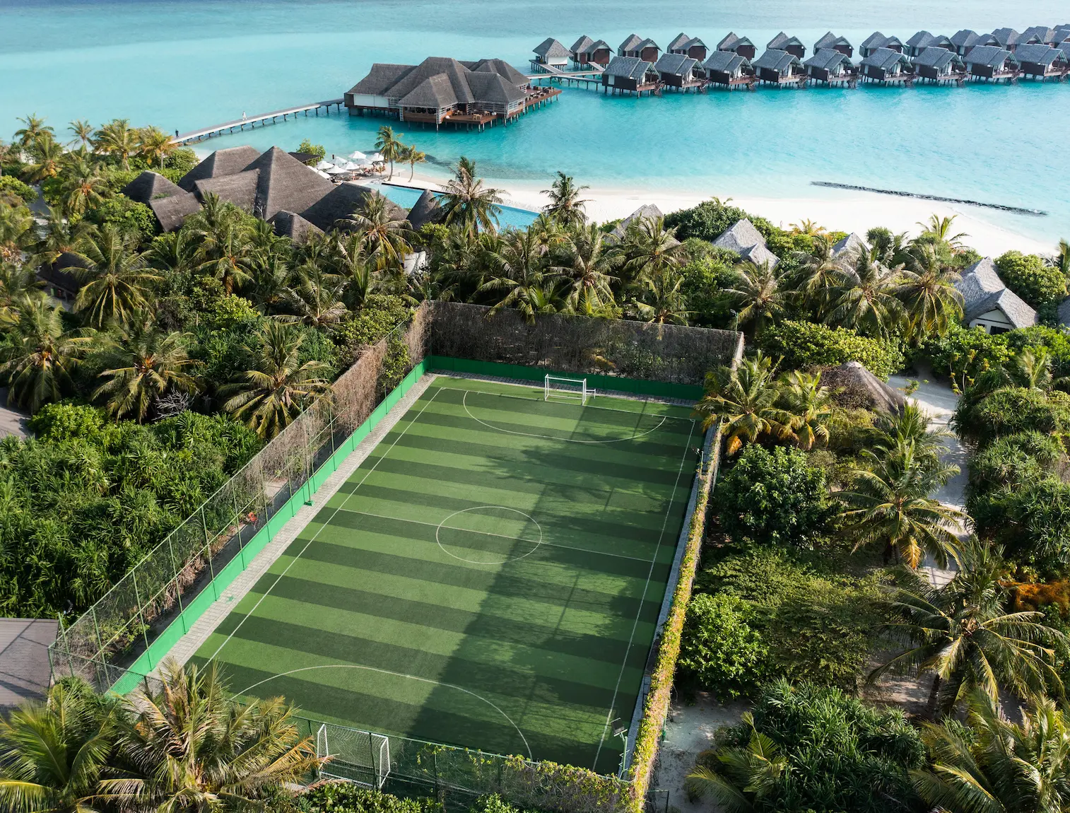 heritance aarah maldives futsal aerial view capturing the island’s vibrant outdoor court surrounded by tropical greenery and ocean horizons