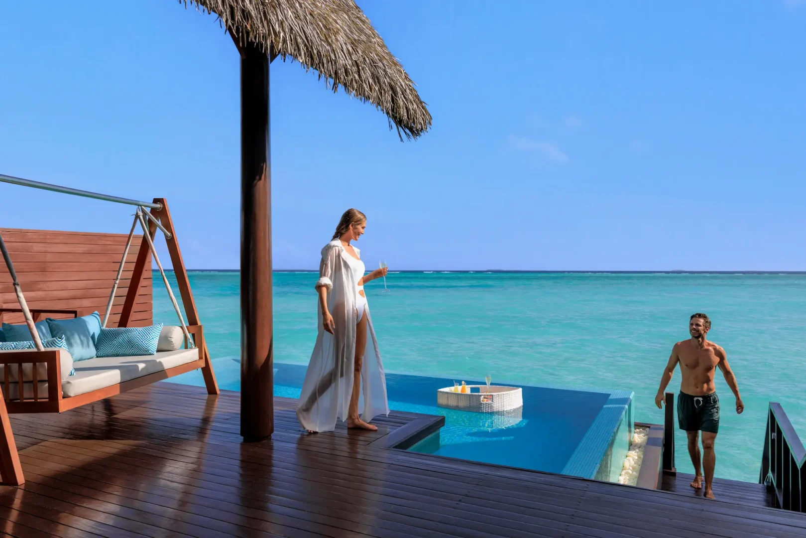heritance aarah maldives ocean suite sun deck couple enjoying a serene overwater setting with warm tropical ambience