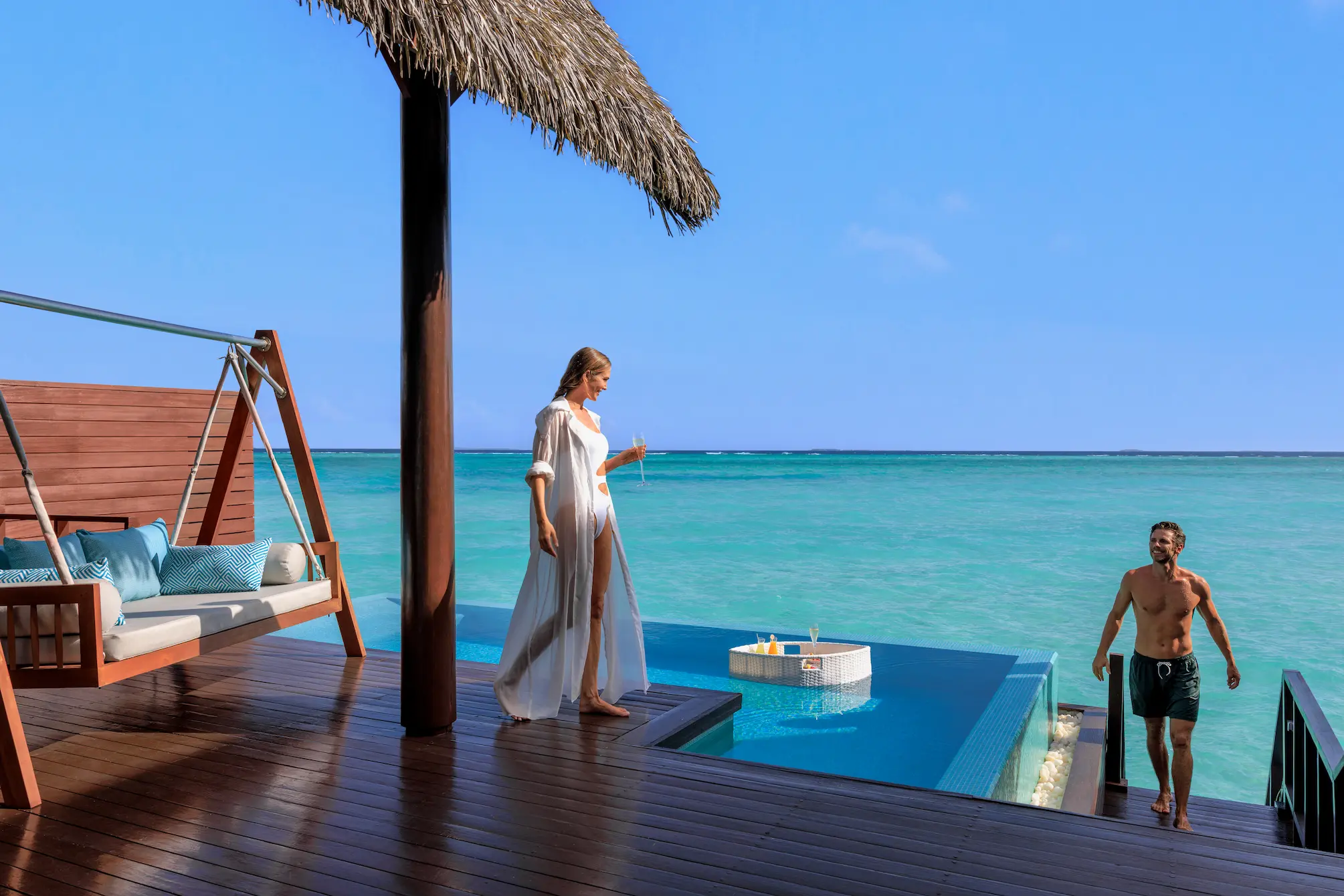 heritance aarah maldives ocean suite sun deck couple enjoying a serene overwater setting with warm tropical ambience