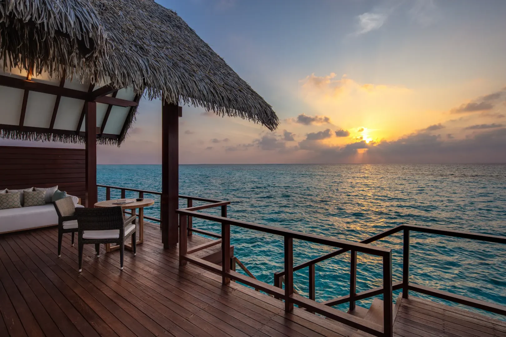 heritance aarah maldives ocean villa deck at sunset featuring a serene overwater setting with warm golden light and tranquil lagoon views