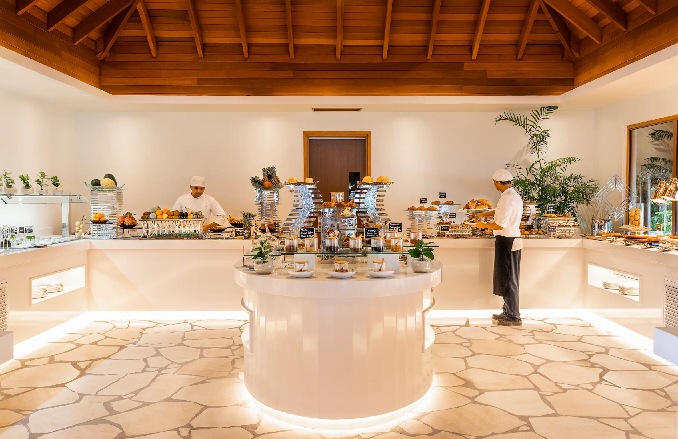 huvafen fushi maldives celcius showcasing a tranquil beachfront dining space with soft tropical light and refined island ambience
