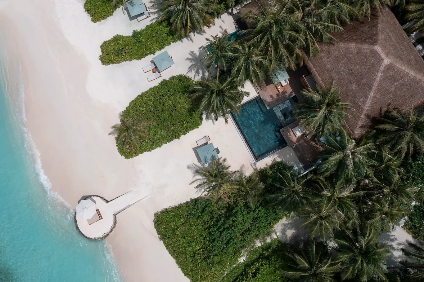 huvafen fushi maldives two bedroom beach house with pool aerial capturing a spacious beachfront residence surrounded by turquoise lagoon waters and lush tropical greenery