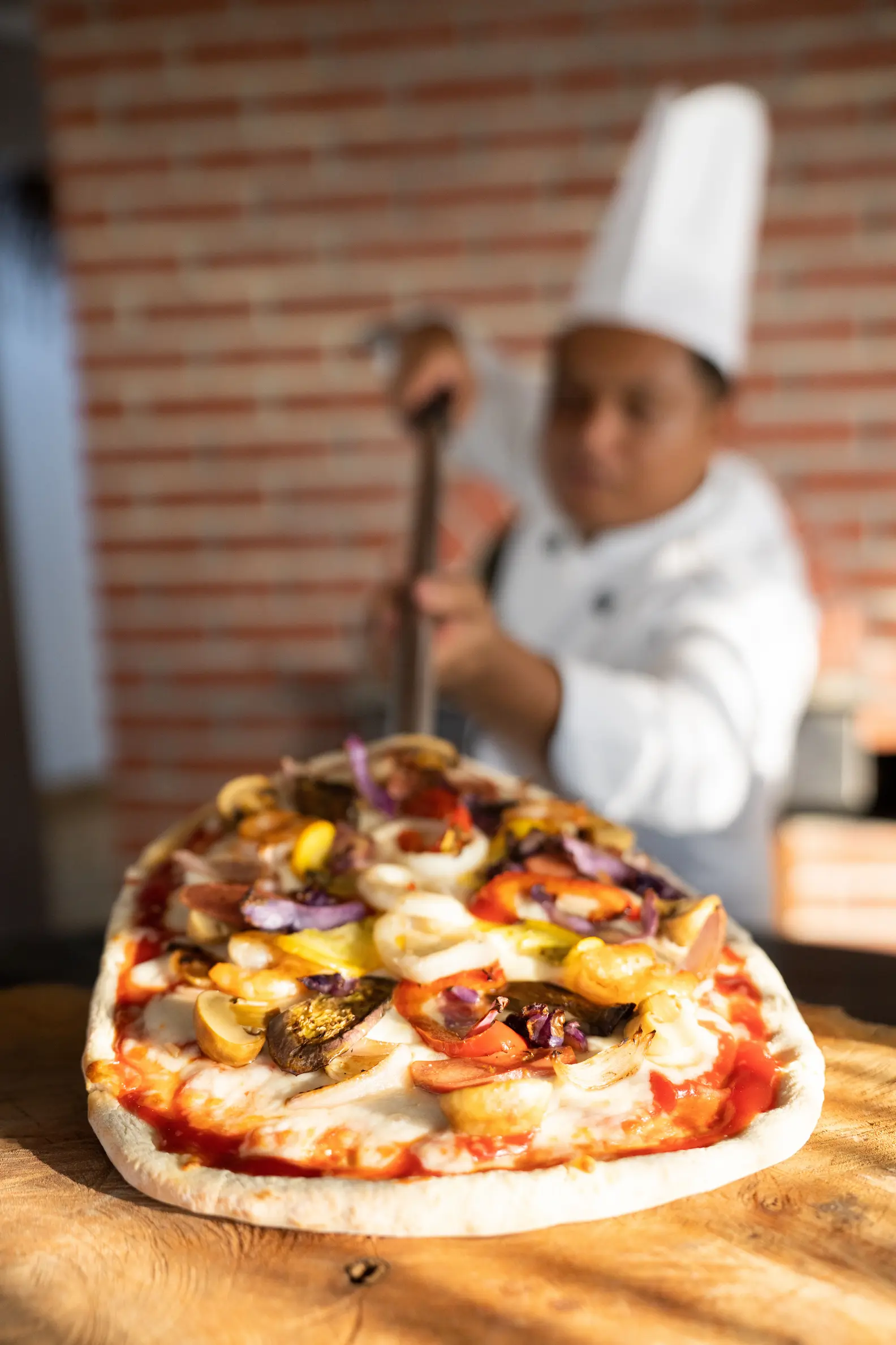 ifuru island maldives pool side pizza chef preparing fresh pizza in a relaxed contemporary island setting with serene luxury ambience
