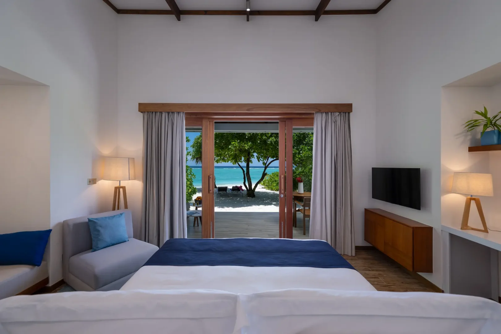 ifuru island maldives sunset beach villa bedroom view with serene island luxury and refined contemporary design overlooking the beach