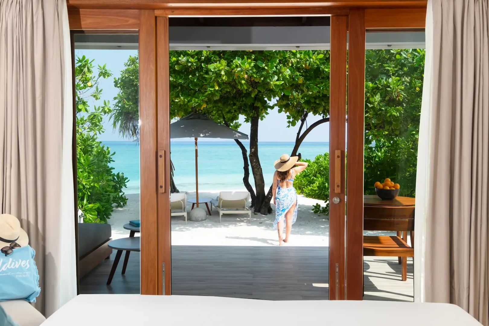 ifuru island maldives sunset beach villa outdoor lifestyle scene with serene island luxury and elegant contemporary beachfront ambience