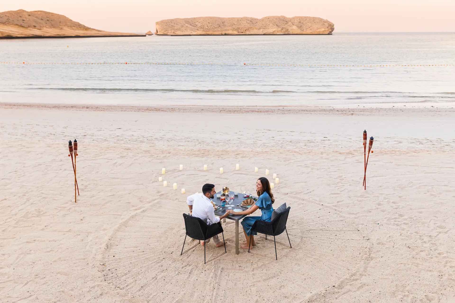 romantic dinner at jumeirah muscat bay oman featuring beachfront dining candlelit tables and ocean view luxury resort setting
