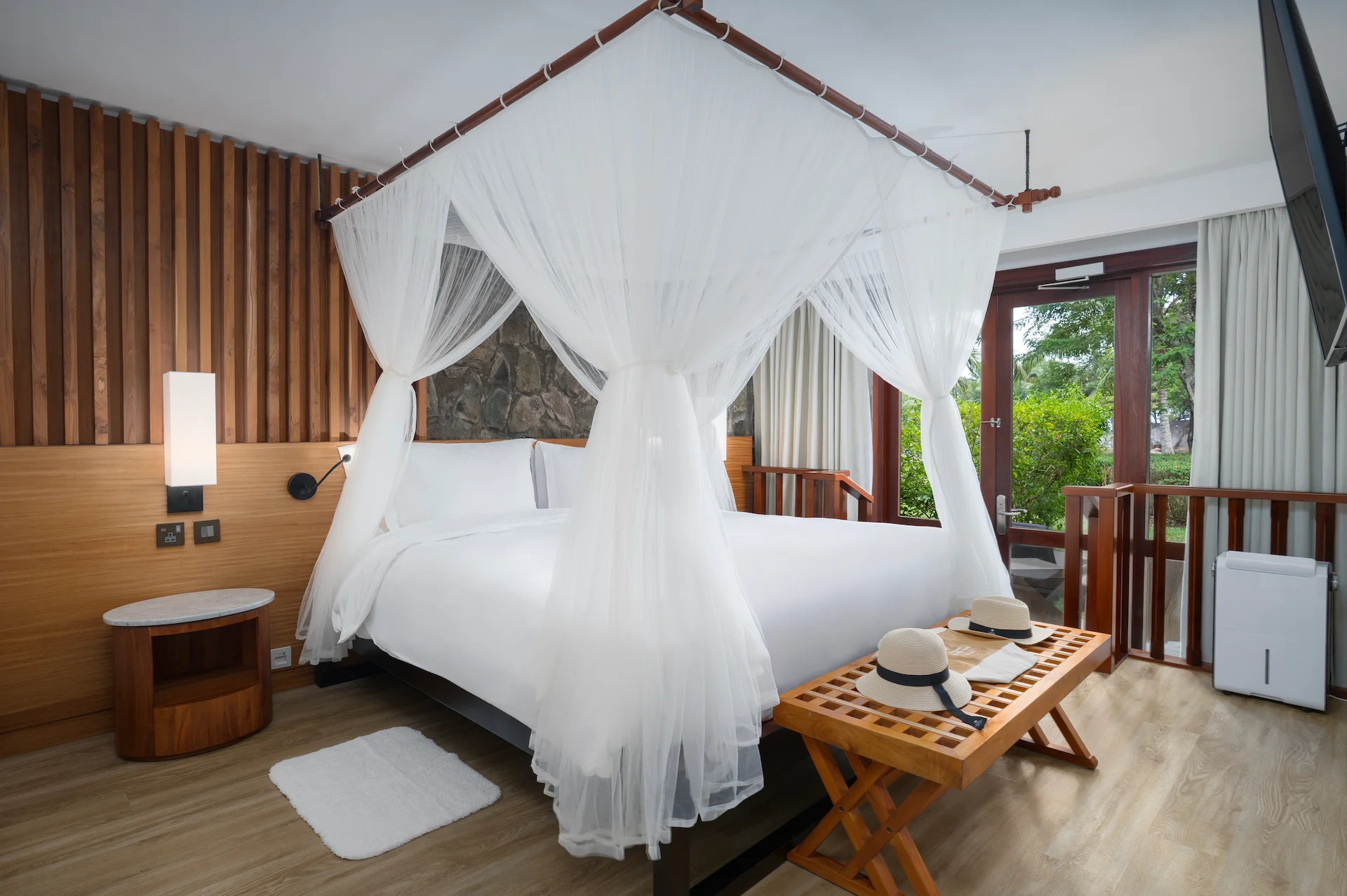 kempinski seychelles resort deluxe lagoon view suite bedroom with bed and lagoon view