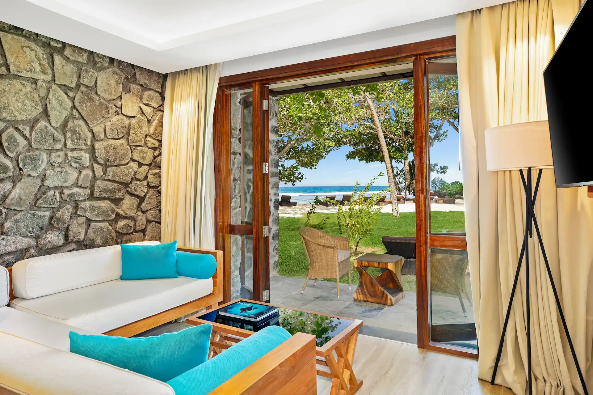kempinski seychelles resort family room lounge area with seating and ocean view